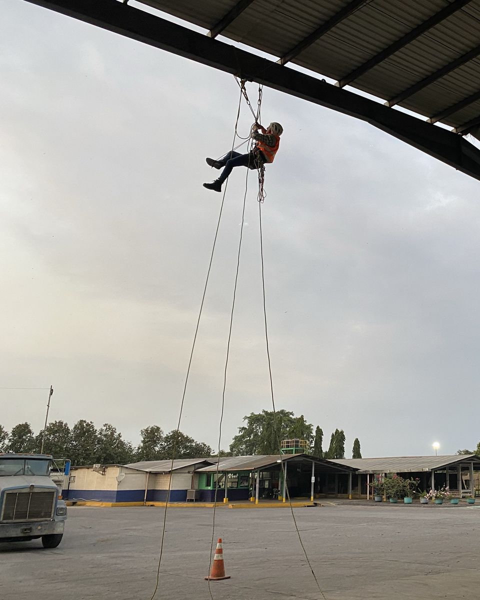 Técnico de Vertika suspendido con cuerdas en el borde del techo de las bahías de carga