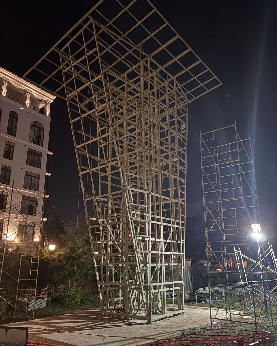 Estructura metálica de El Muro a medio construir, de noche y con andamios